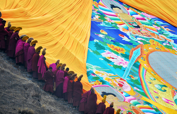 На северо-западе Китая в провинции Ганьсу монахи монастыря Лабранг провели церемонию открытия гигантской тхангки — полотна с изображением Будды, которое ежегодно раскладывают на холме у монастыря. Весь процесс сопровождался распеванием молитв и благословением участников церемонии.