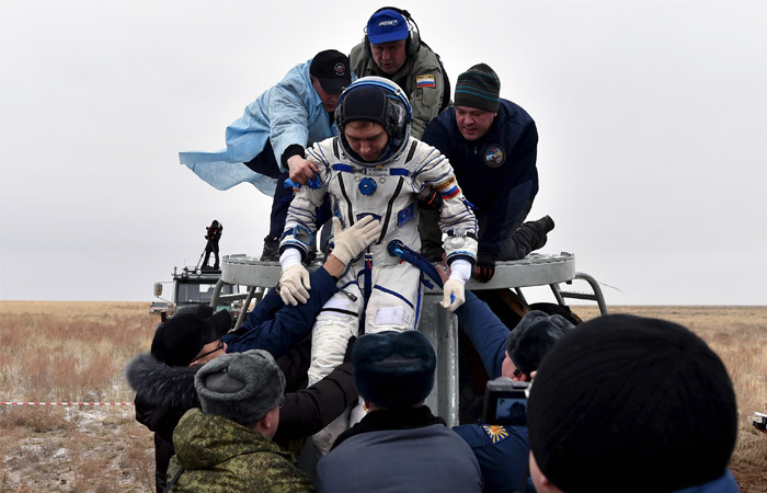 Специалисты поисково-спасательных групп эвакуируют Сергея Волкова из спускаемого аппарата