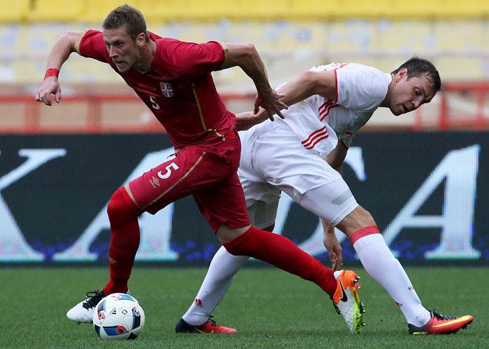 Защитник сборной Сербии Слободан Райкович (№5) в противостоянии с российским форвардом Артемом Дзюбой