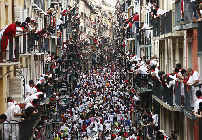 Жители испанского Памплона наблюдают за бегом быков во время фестиваля Сан-Фермин