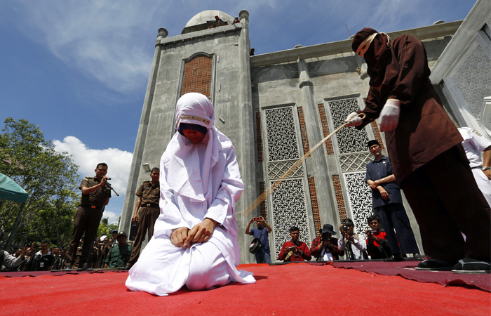 В индонезийском городе Банда-Ачех молодую девушку наказали за близкие отношения вне брака. Ослушавшуюся правил шариата вывели на одну из площадей, где публично нанесли несколько ударов тростью.