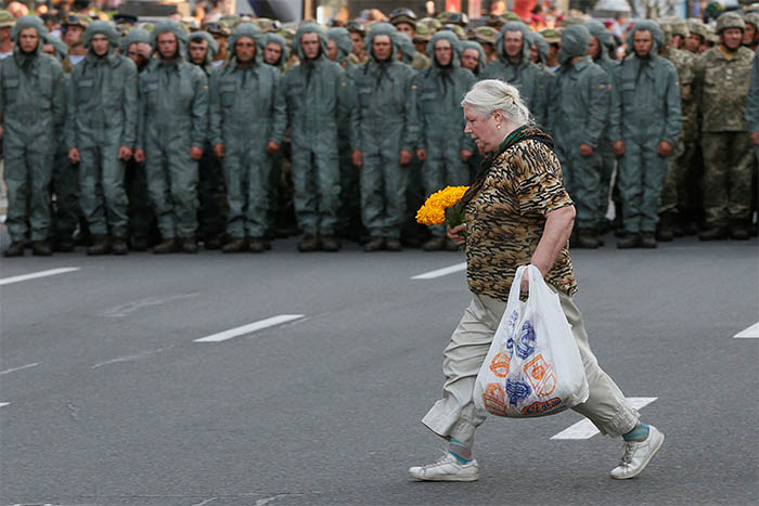 Солдаты репетируют построение перед Днем независимости Украины, но этой женщине это совсем не мешает. Киев.