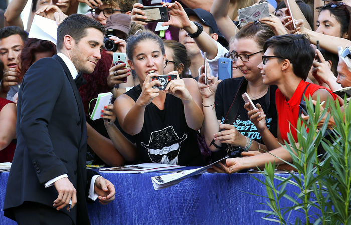 Актер Джейк Джилленхол раздает автографы на красной ковровой дорожке Венецианского кинофестиваля