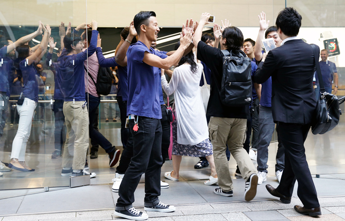 Работники магазина в Токио приветствуют первых покупателей нового iPhone