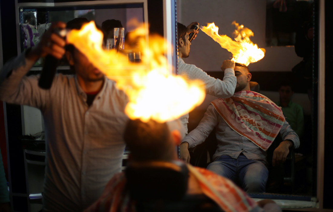 В одной из парикмахерских Палестины набирает популярность необычный способ стрижки и укладки волос. Парикмахер Рамадан Эдван, работающий в лагере для беженцев в секторе Газа, делает прически своим клиентам с помощью огня.