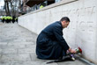 Мужчина кладет цветы к зданию правоохранительных органов Лондона в память о погибшем полицейском