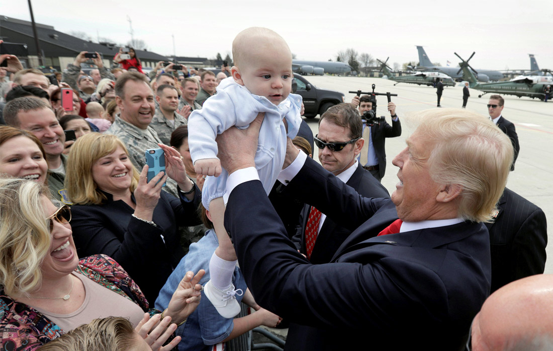 Подавляющее большинство американцев, отдавших свои голоса на президентских выборах в поддержку Дональда Трампа, не разочаровались в его кандидатуре и поддерживают его деятельность на посту президента США. На фото: Трамп берет на руки ребенка жительницы города Милуоки (штат Висконсин), пришедшей поприветствовать президента. У самого бизнесмена пятеро детей от трех жен и уже восемь внуков.