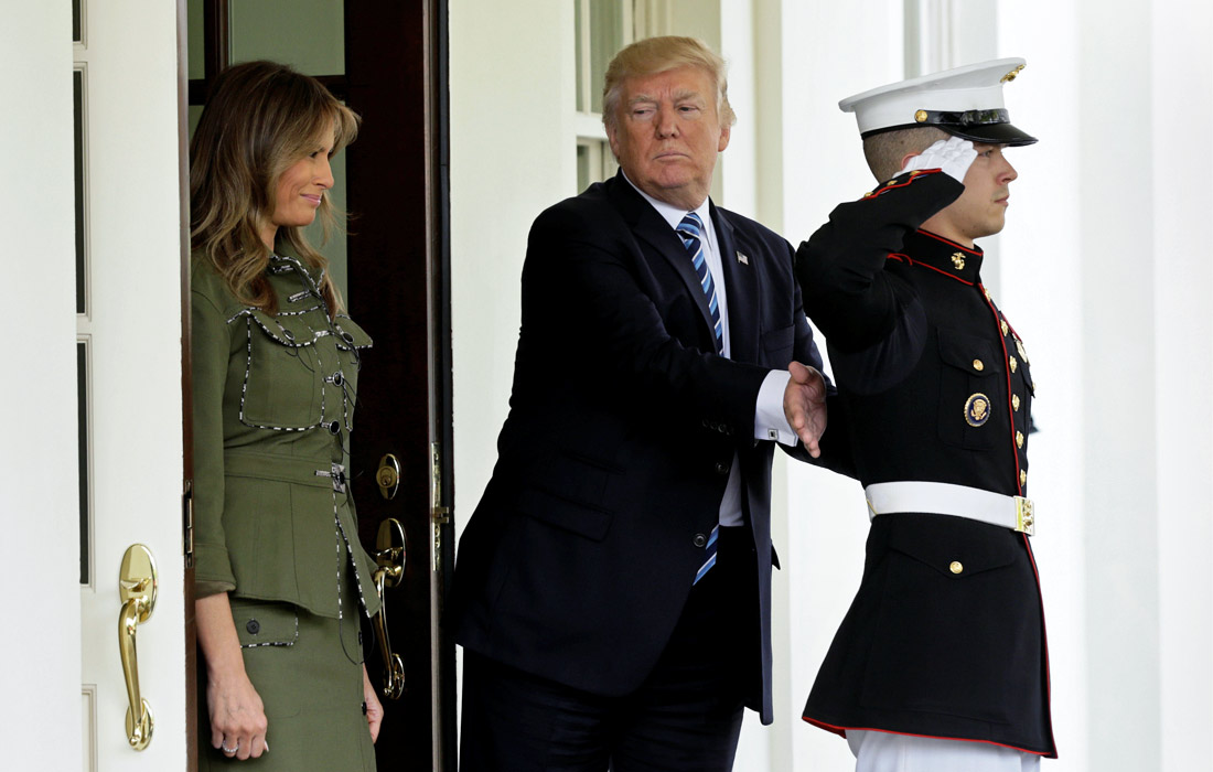 Президент США Дональд Трамп хлопает морского пехотинца по спине перед отъездом из Белого дома в Вашингтоне