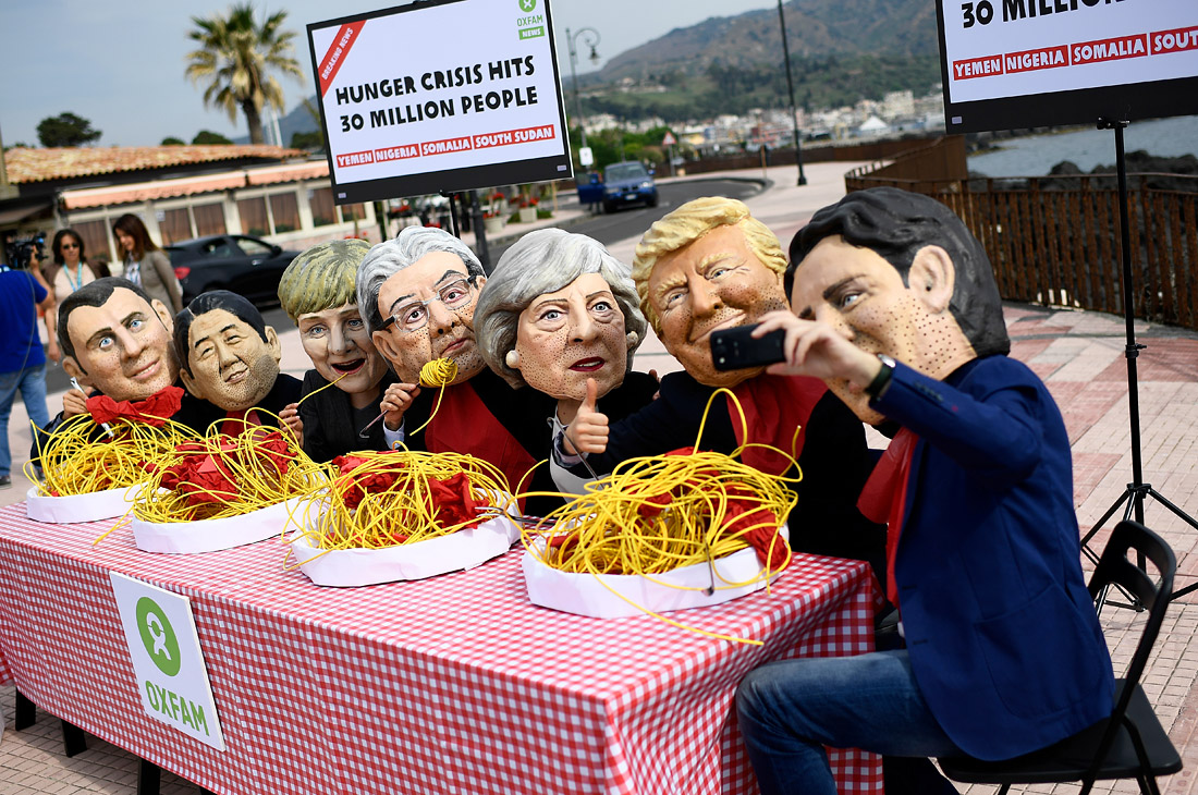 Члены организации Оксфам в масках с изображением лидеров стран "большой семерки" устроили демонстрацию в преддверии саммита G7 в итальянской Таормине