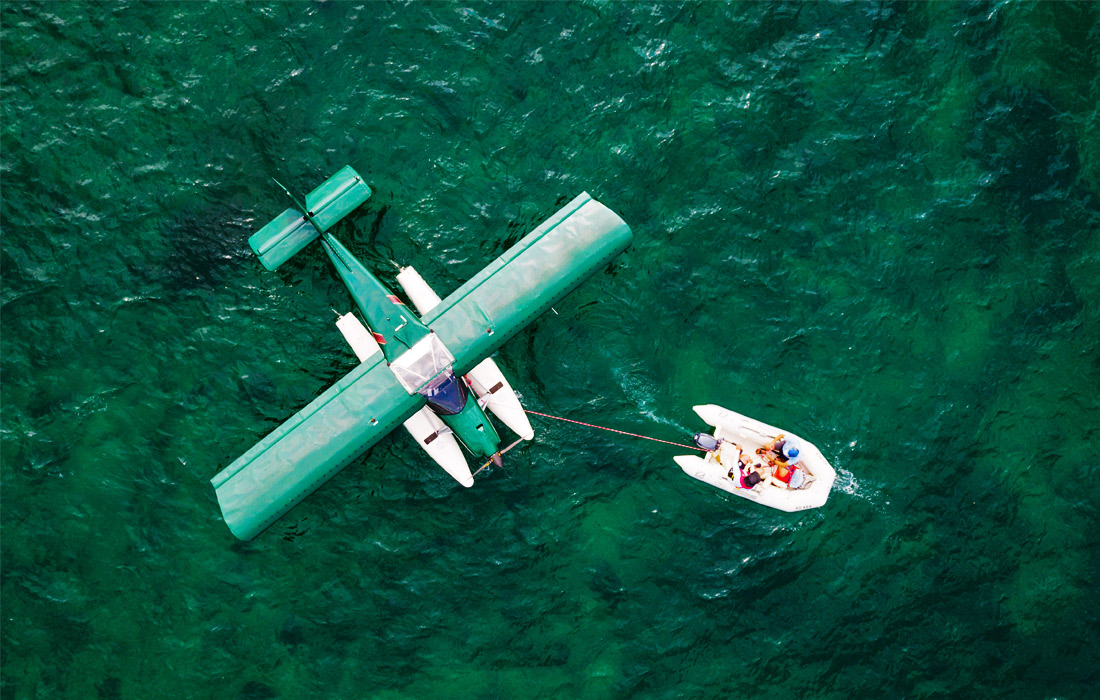 Лодка буксирует гидроплан на Женевском озере в Швейцарии