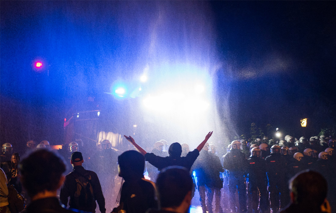 В ночь на среду в парке на западе Гамбурга немецкая полиция применила водометы и перцовый спрей, чтобы разогнать толпу из сотен человек, которые пытались блокировать дороги