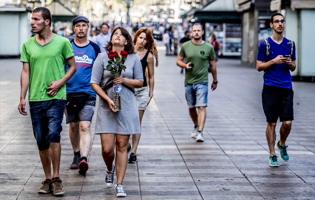 Жители Барселоны несут цветы на место трагедии