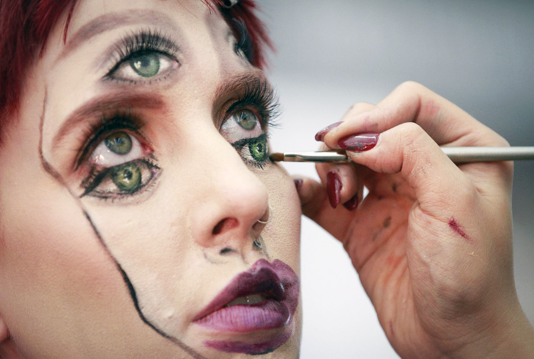 Визажист готовит модель к участию в международной выставке индустрии красоты в Ванкувере. Канада.