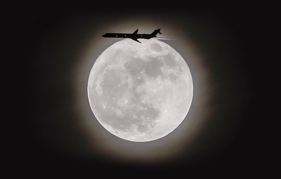 Самолет, летящий на фоне суперлуния, Авондейл-Эстейтс, США