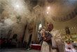 Священник держит статуэтку младенца Иисуса во время рождественской мессы в Каире, Египет