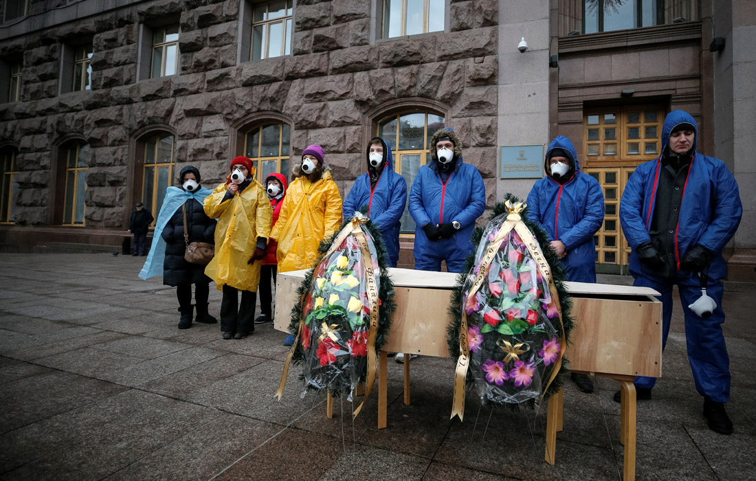 У здания мэрии Киева активисты в костюмах химической защиты провели акцию протеста против размещения завода по производству фанерных плит вблизи жилых районов столицы