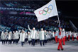 Сборная олимпийских атлетов из России принимает участие в параде стран-участниц под нейтральным флагом, который несет волонтер оргкомитета Игр