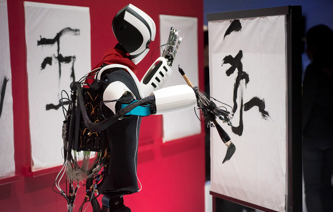 Оператор с помощью технологии 5G в режиме реального времени манипулирует роботом, который точно воспроизводя его движения, рисует японские иероглифы