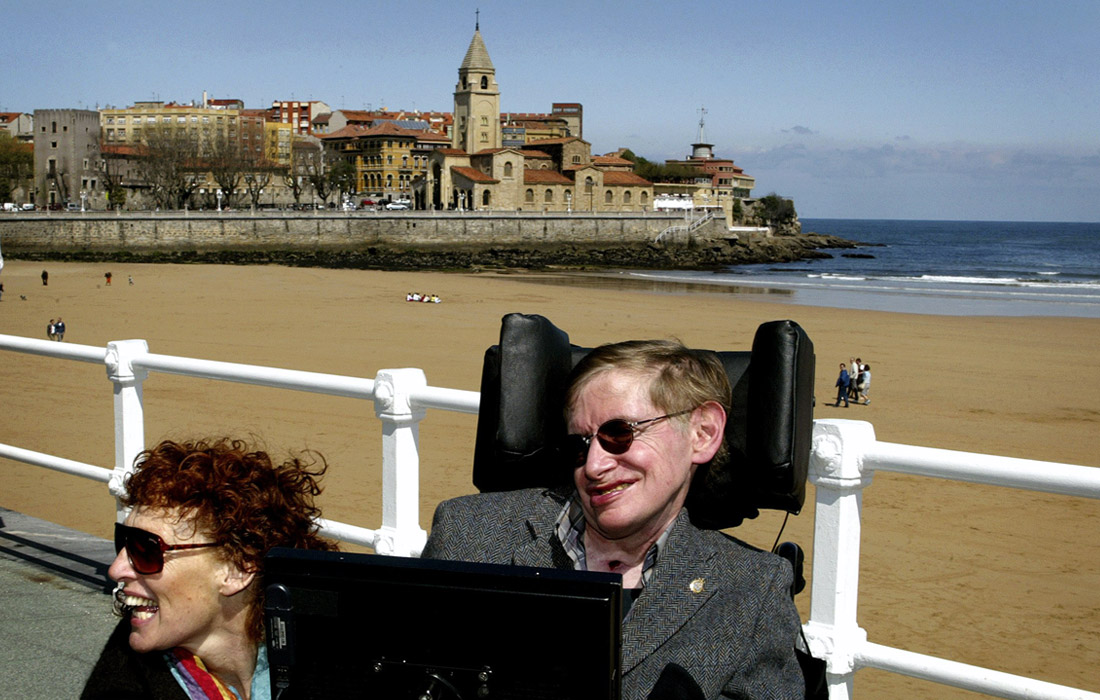 Тяжелое заболевание, почти на 40 лет приковавшее ученого к инвалидному креслу, не помешало ему вести активный образ жизни, много путешествовать и продолжать свои научные исследования. На фото: Стивен Хокинг с женой Элайн на пляже Сан-Лоренцо в испанском городе Хихон в апреле 2005 года.