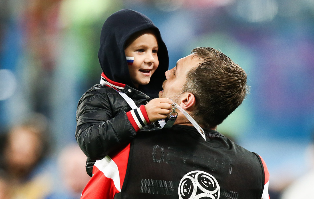 Игрок сборной России Артем Дзюба с сыном после победы команды в матче группового этапа чемпионата мира по футболу между сборными России и Египта