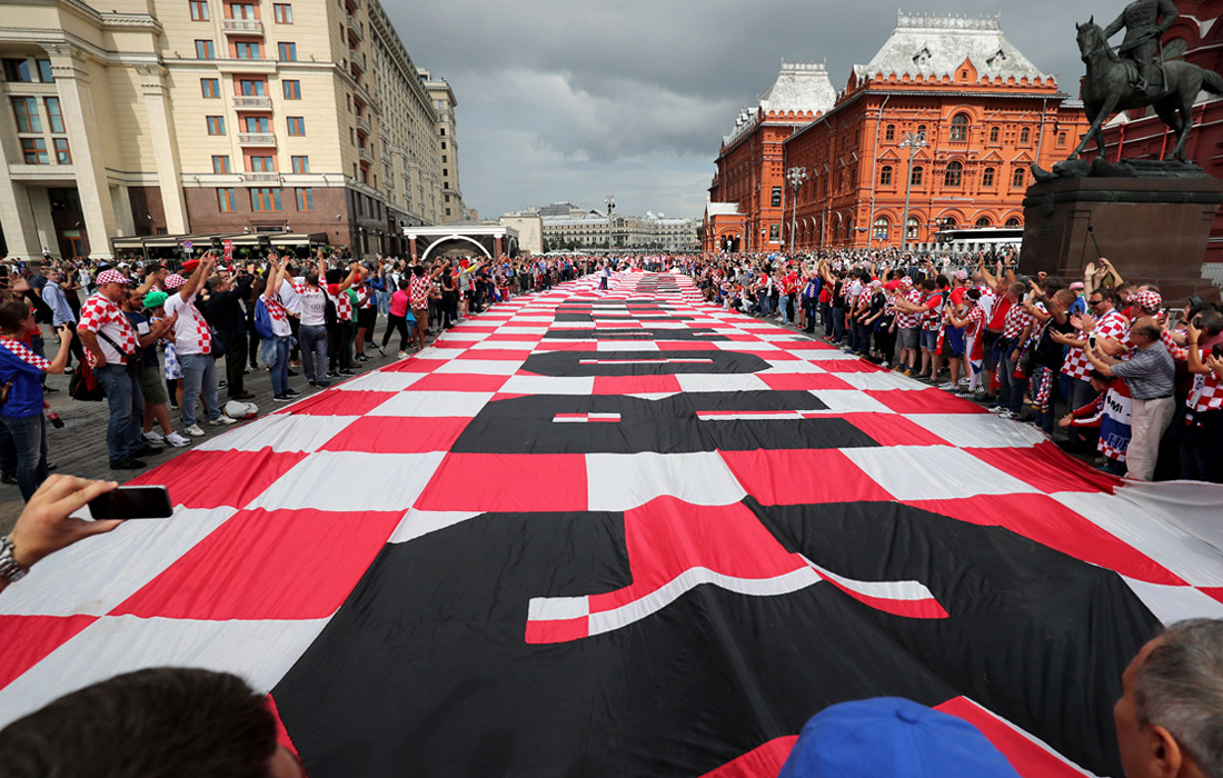 Футбольные болельщики из Хорватии развернули в центре Москвы огромный флаг в красно-белую клетку, как на гербе их страны, в преддверии полуфинала чемпионата мира по футболу между сборными Хорватии и Англии