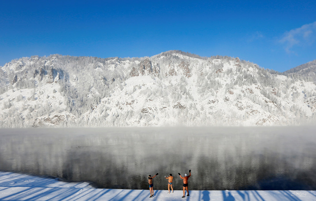 Члены клуба зимнего плавания "Дельфин" разминаются на берегу Енисея перед еженедельным купанием