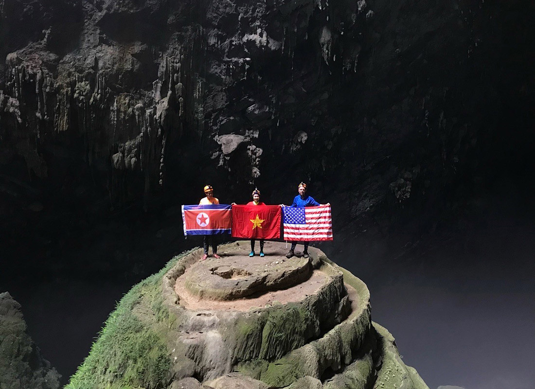 Туристы с флагами Северной Кореи, Вьетнама и США в самой большой пещере в мире Шондонг в национальном вьетнамском парке Фонгня-Кебанг накануне саммита в Ханое