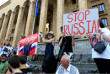 Протестующие рядом со зданием парламента держат антироссийские плакаты