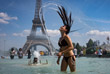 Девушка спасается от 30-градусной жары в фонтане Трокадеро в центре Парижа