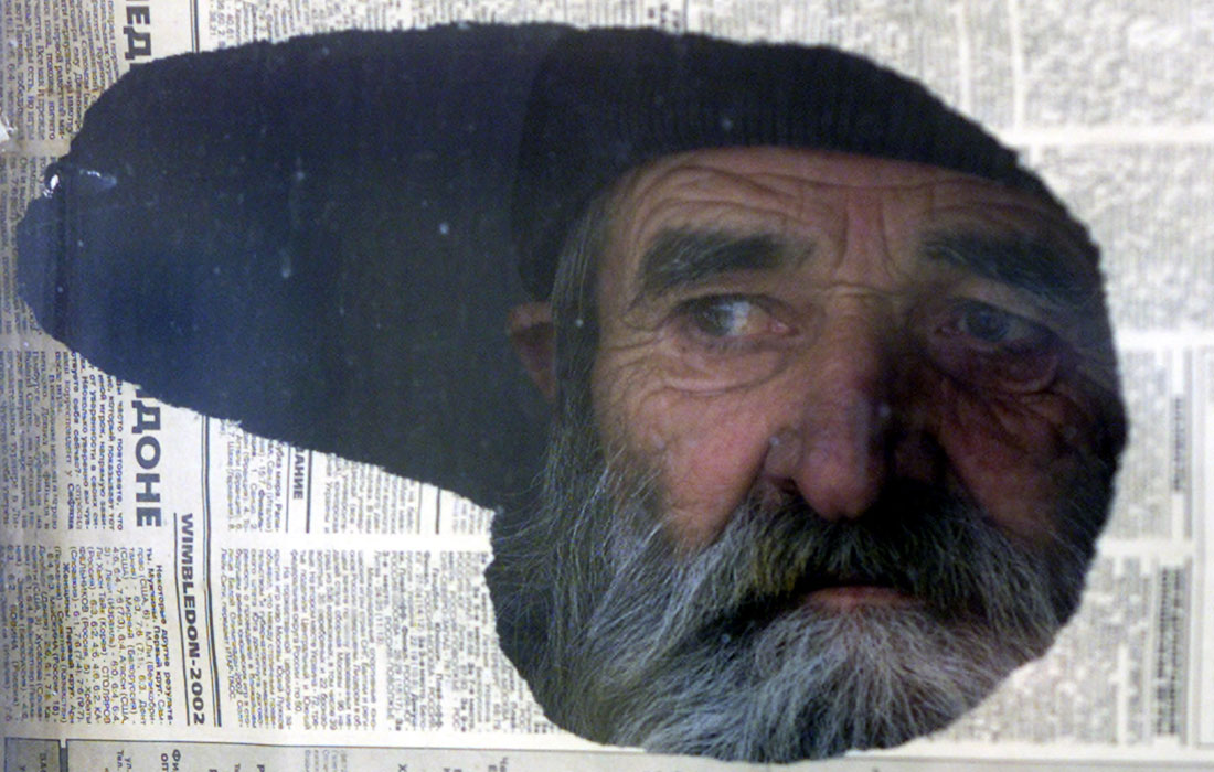 Пожилой мужчина смотрит из окна центра для беженцев в Грозном. 11 декабря 2002 год.