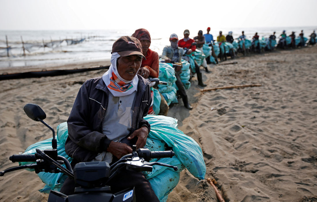 В Западной Яве пострадавшая от разлива нефти береговая линия в Караванге была засыпана песком