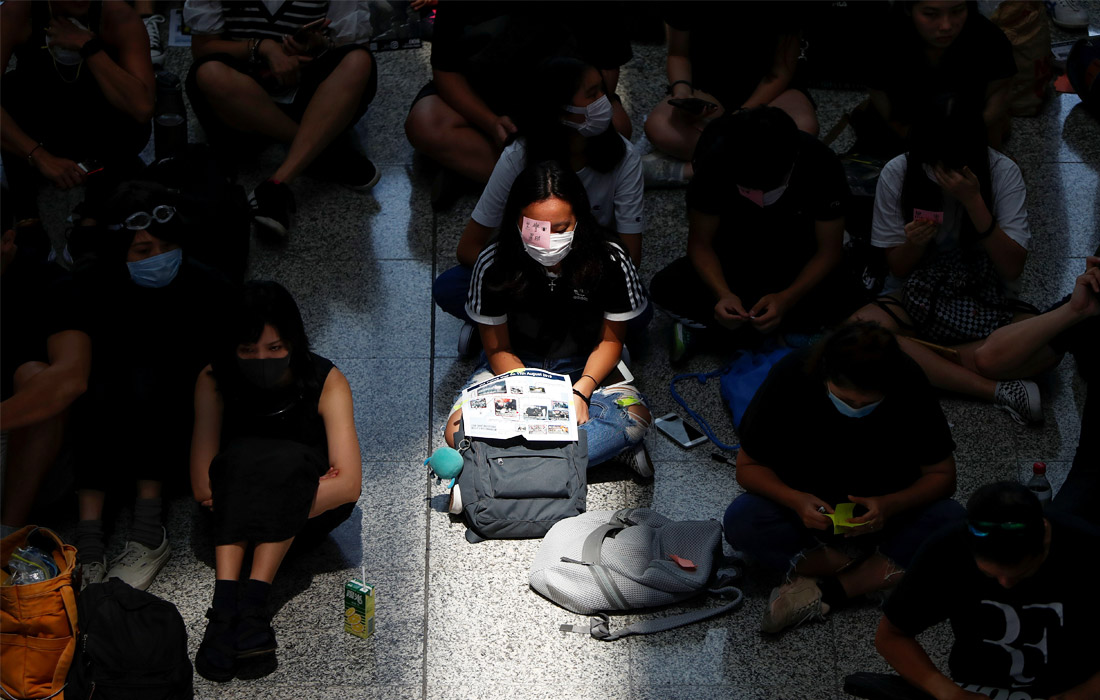 Международный аэропорт Гонконга отменил все рейсы в понедельник из-за того, что в главном терминале скопилось несколько тысяч протестующих. У некоторых демонстрантов в руках плакаты с изображением глаза: одна из участниц протестов лишилась зрения после того, как ей в глаз попала резиновая пуля. Некоторые протестующие закрывают один глаз стикерами или повязками.