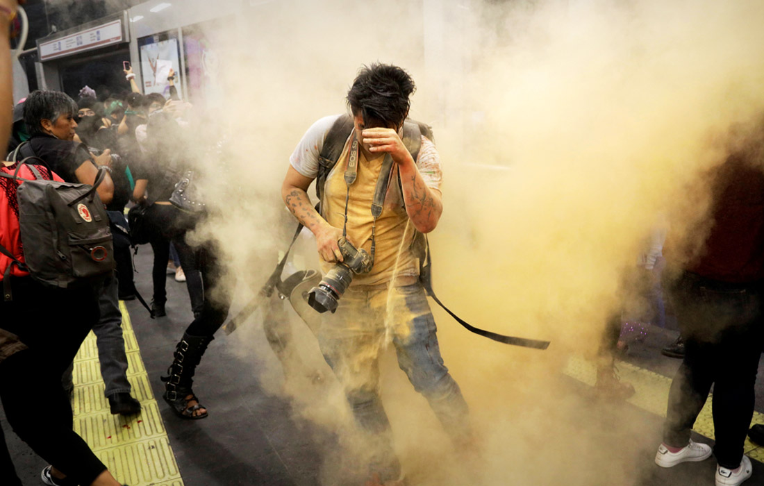 Фотограф во время акции протеста из-за изнасилования полицейскими двух девушек-подростков в Мехико. Август 2019 года.