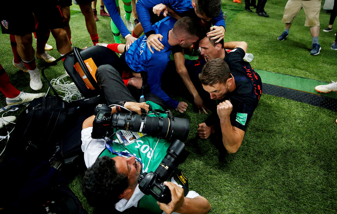 Игроки сборной Хорватии случайно повалили фотографа Юри Кортес из агентства AFP, празднуя второй гол в ворота Англии в полуфинале Чемпионата мира по футболу. Июль 2018 года.