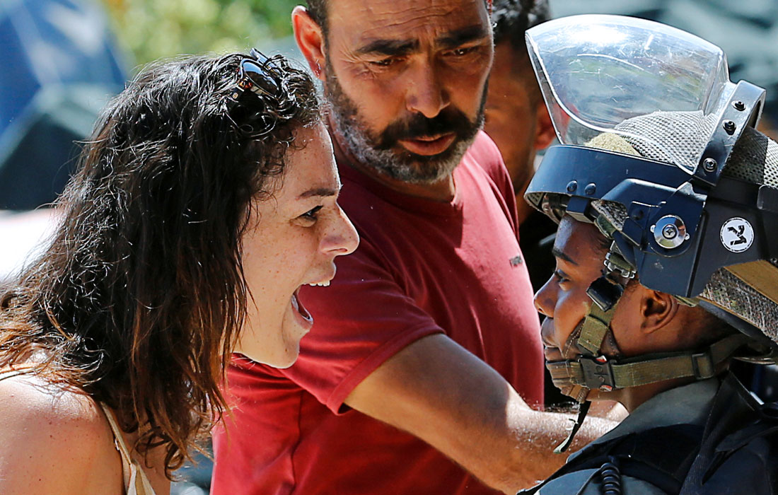 Женщина спорит с израильским полицейским из-за сноса дома в городе Бейт-Джала на Западном берегу реки Иордан. Власти Израиля считают, что здание было возведено без разрешения.