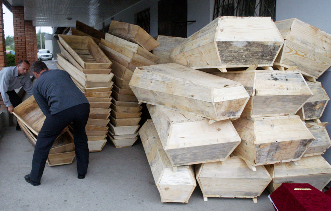 Рабочие готовят гробы для похорон первых из 333 убитых заложников, 5 сентября 2004 года