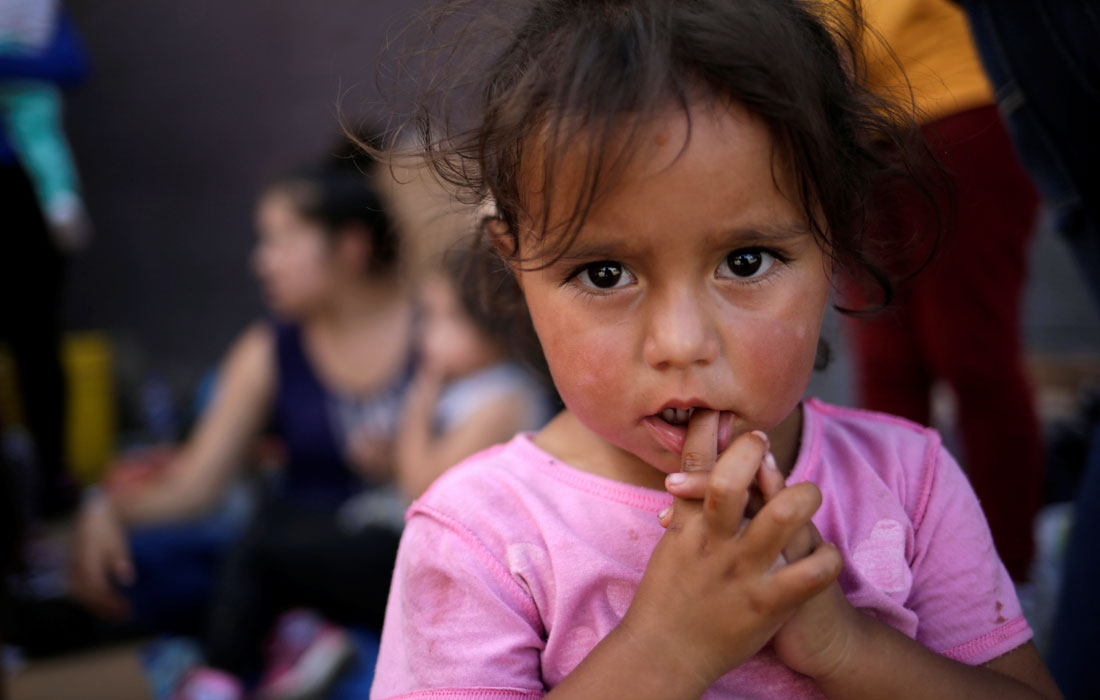 Мексиканская девочка со своими родителями ожидает в очереди, чтобы подать заявление о предоставлении убежища в США на пограничном мосту в Сьюдад-Хуарес