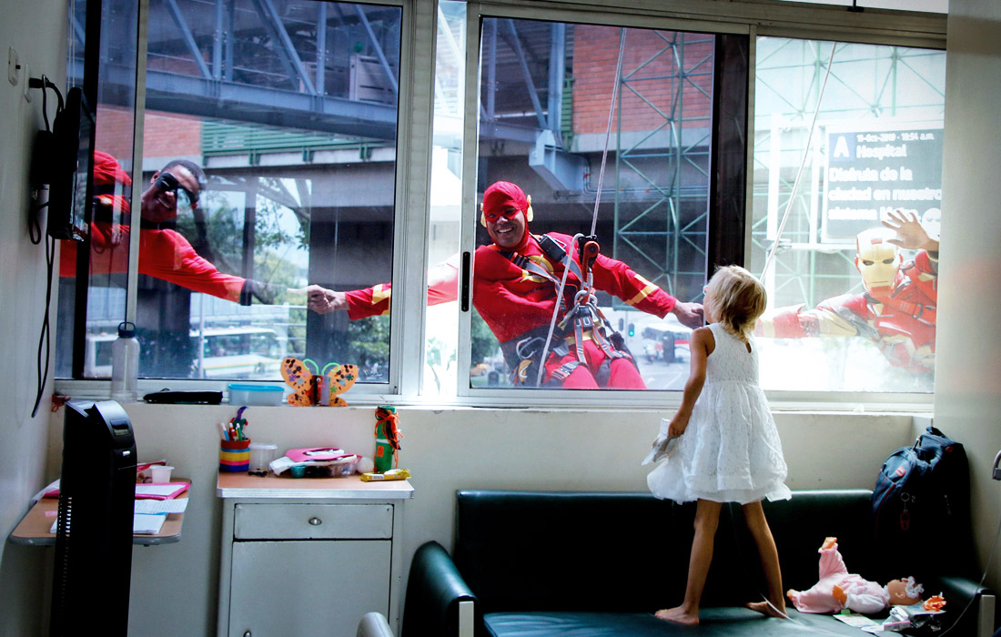 Альпинисты в костюмах супергероев во время посещения пациентов детской больницы в Медельине, Колумбия