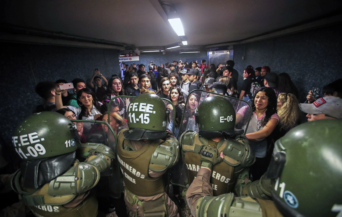 Волна протестов началась в Сантьяго около двух недель назад. Сотни школьников и студентов ездили без билетов, перепрыгивали через турникеты и устраивали акции протеста в подземке.