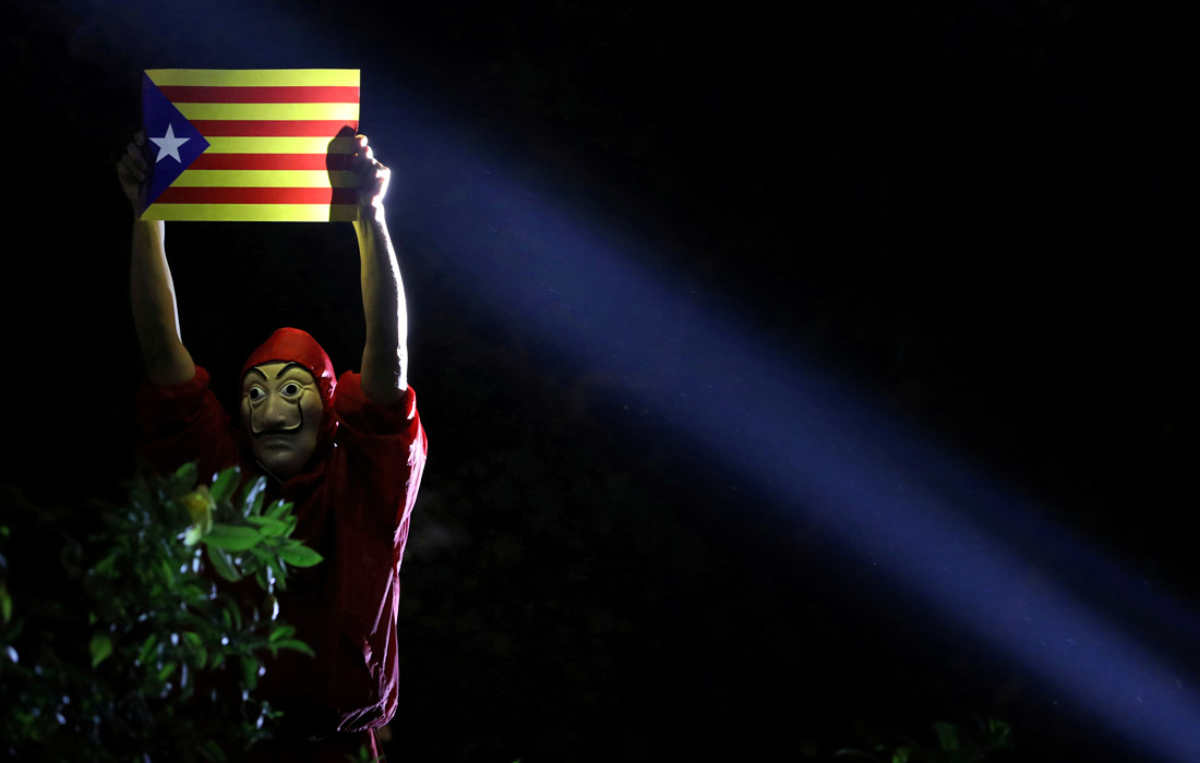 Участник акции протеста в Гонконге демонстрирует свою солидарность с движением за независимость Каталонии