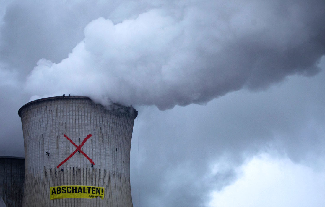 Активисты Гринпис взобрались на градирню, чтобы вывесить плакат с надписью "Выключи!" на электростанции Neurath, работающей на буром угле, в Гревенброхе, Германия