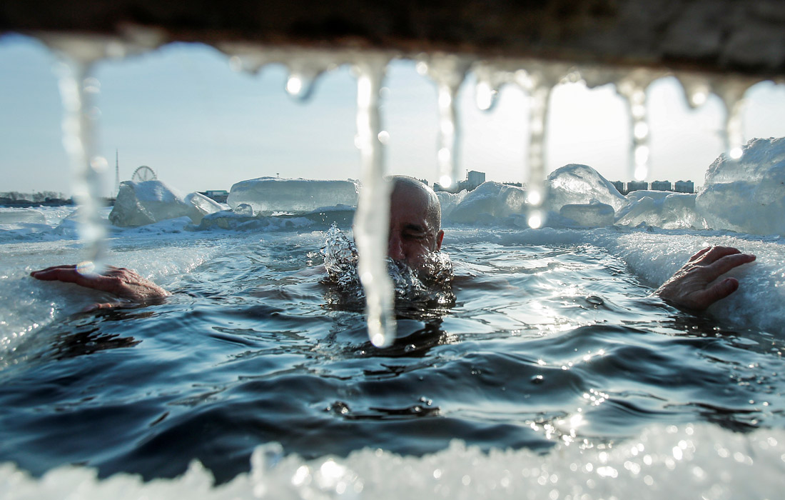 Купание в проруби на приграничной реке Амур, разделяющей российский Благовещенск и китайский Хэйхэ