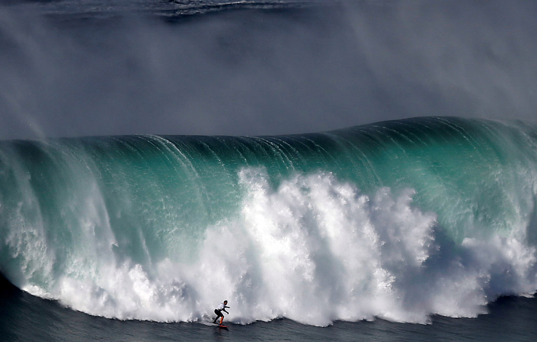 Серфер покоряет гигантскую волну в Назаре, Португалия. 2 ноября.