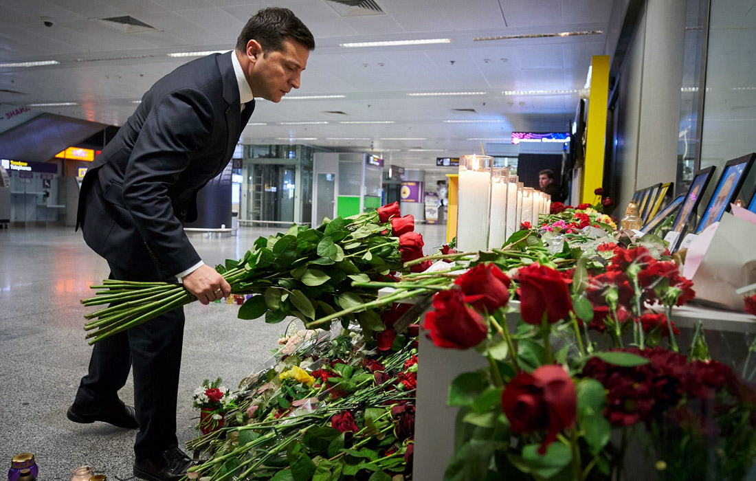 Президент Украины Владимир Зеленский возлагает цветы к фотографиям погибших в аэропорту "Борисполь"