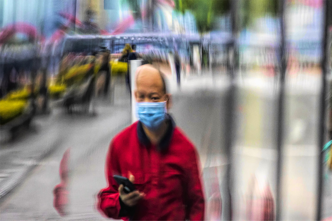 Мужчина ждет автобус на остановке в Гуанчжоу