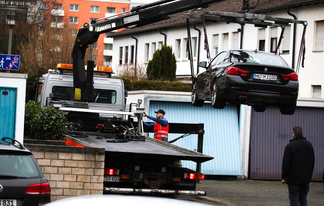 Эвакуация автомобиля, предположительно принадлежащего подозреваемому стрелку, на месте преступления