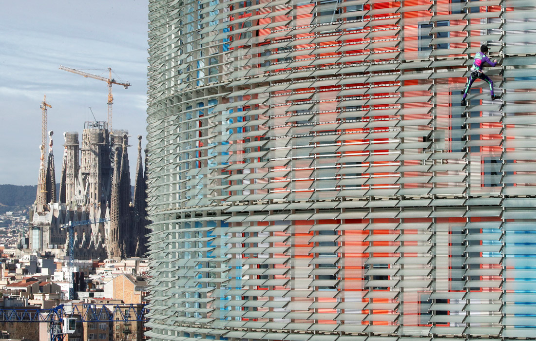 Знаменитый французский скалолаз Ален Робер, получивший прозвище "человек-паук" за восхождения без снаряжения и страховки, покорил небоскреб Torre Glories в Барселоне