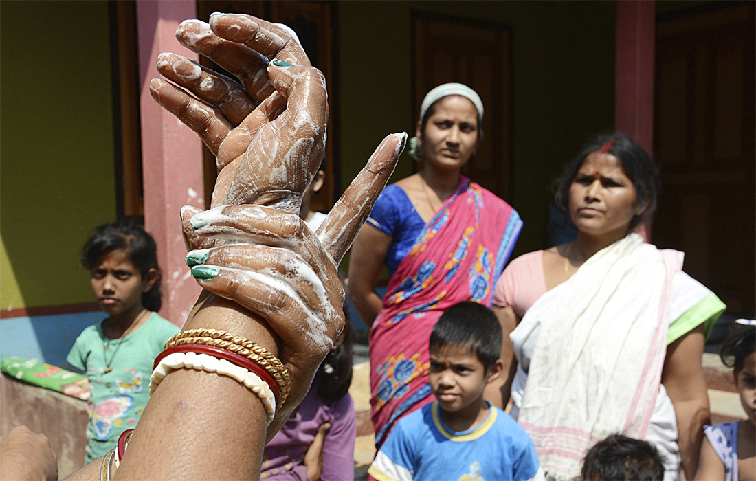 Индийские медработники провели обучение по гигиене рук для местного населения во время кампании по информированию о коронавирусе в деревне Уттар-Пара в Ассаме