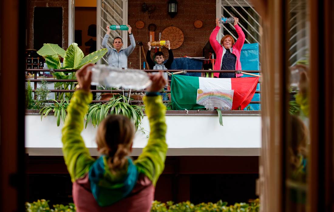 Жители Италии занимаются зарядкой на балконах во время карантина