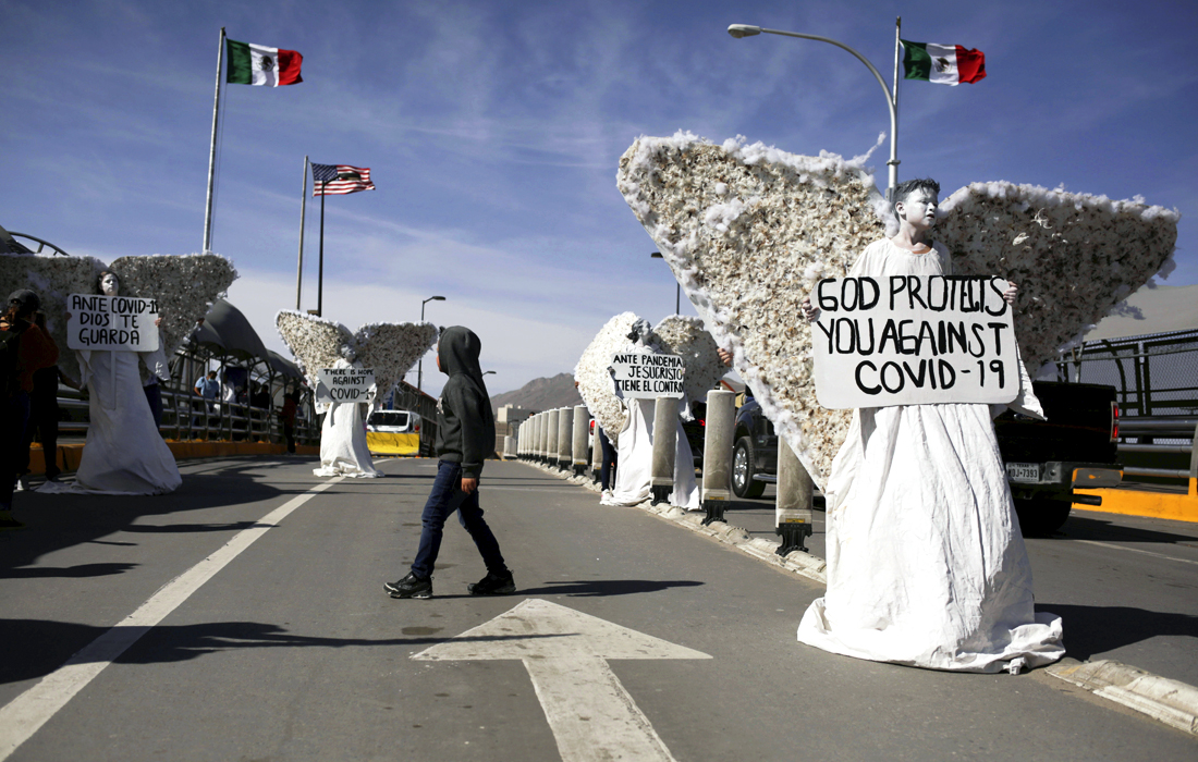 Члены евангелической церкви "Псалом 100" провели демонстрации в костюмах ангелов на международном пограничном мосту в Мексике